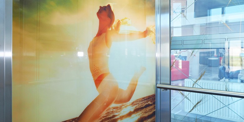 Skleněný design– na levé stěně je mezi skly fotografie ženy na pláži, na zadní stěně jsou mezi skla vloženy klasy obilí